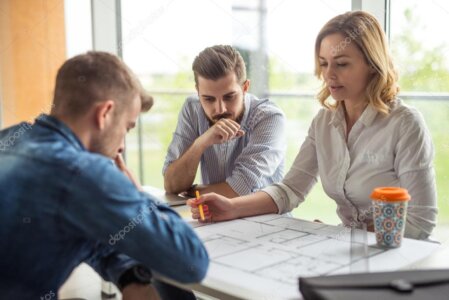 Technical team discussing building plans around a table